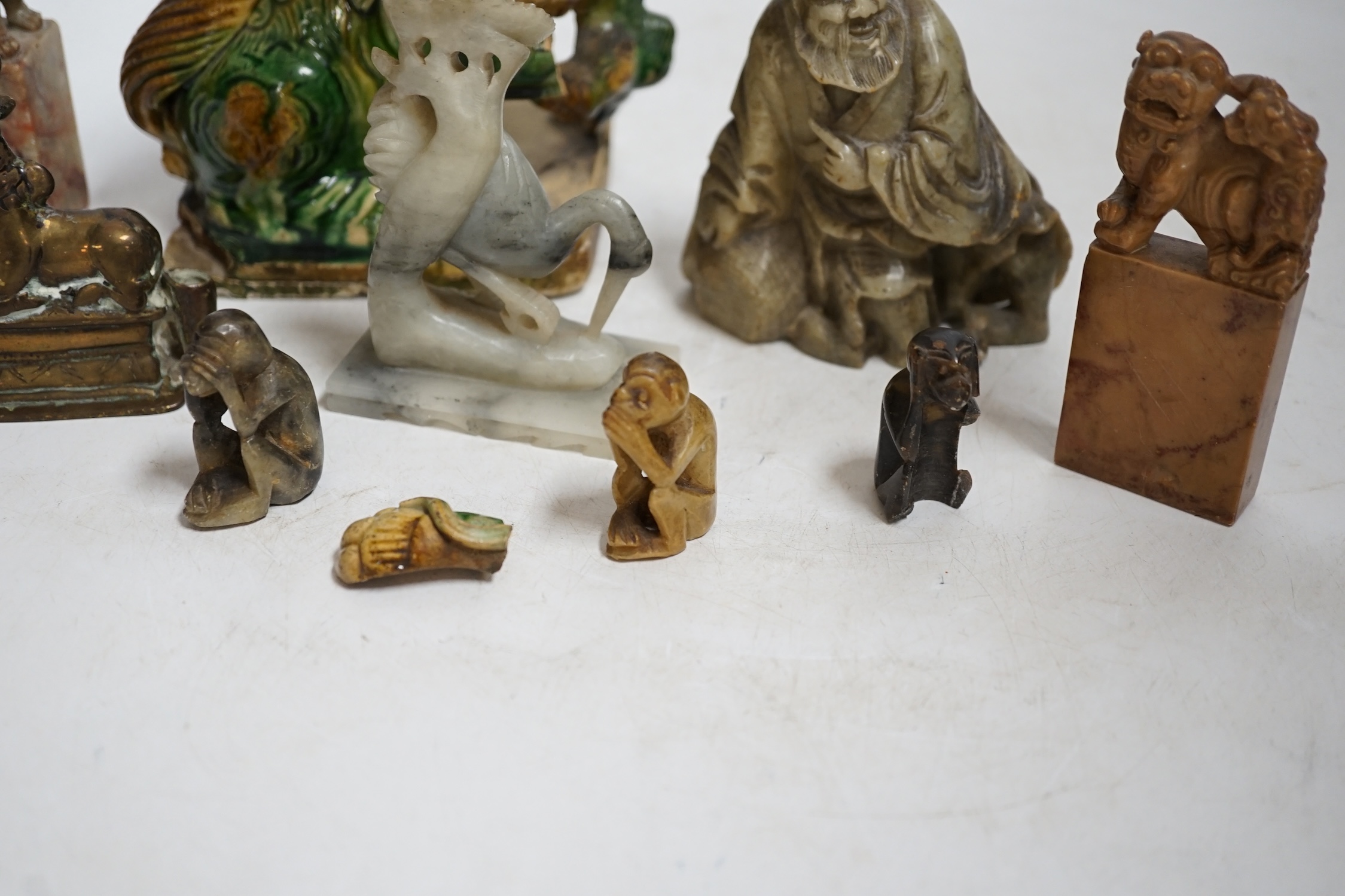 A glazed Chinese lion dog and a collection of soapstone carvings including seals, largest 17cm high. Condition - varies, poor to fair